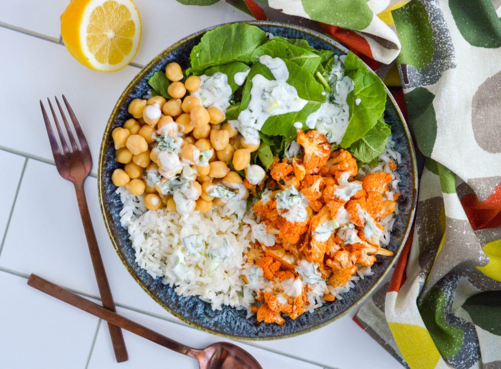 This simple yet luxurious bowl brings together two favorites-- buffalo cauliflower and rice. It’s topped with a delicious homemade herby yogurt sauce, making it the perfect option for a packed lunch or a simple make-ahead dinner. #ricebowl #buffalocauliflower #mealprep #vegetarian