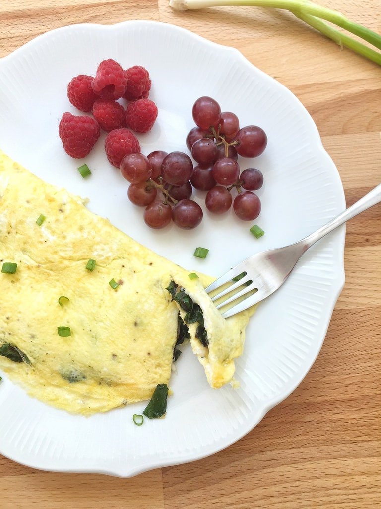 beet green omelet on white plate with grapes