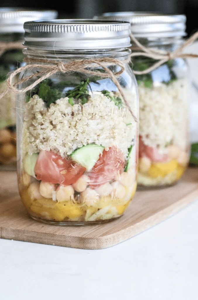 quinoa, veggies and herbs in a glass mason jar salad