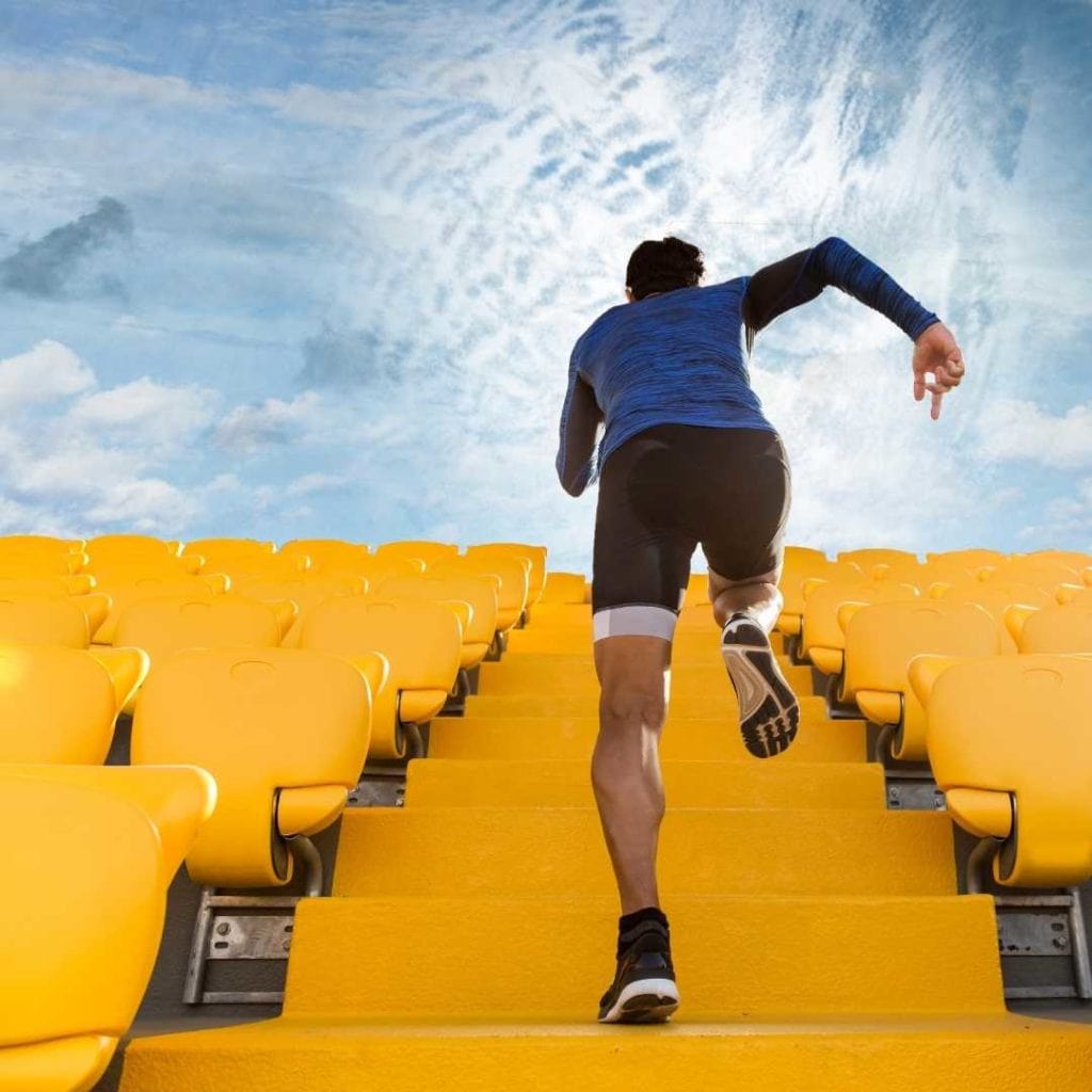 man running up stadium stairs