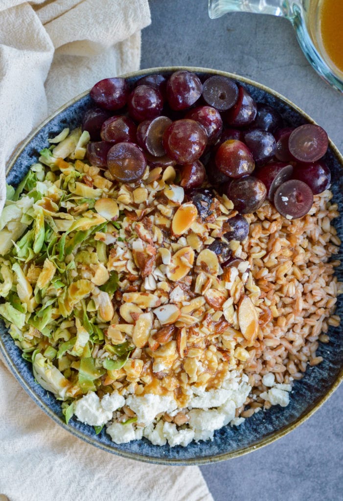 farro salad with feta, sliced almonds, red grapes and sliced brussels sprouts, topped with maple vinaigrette