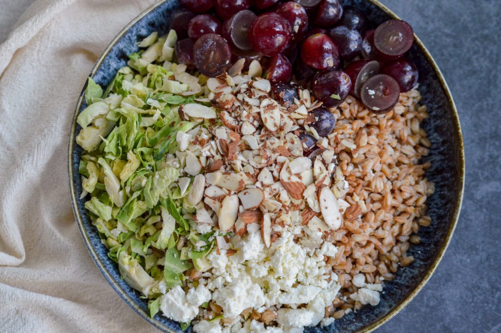 farro salad with feta, sliced almonds, red grapes and sliced brussels sprouts, topped