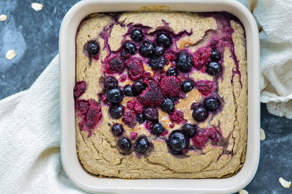 vegan baked oatmeal with berries on top in casserole dish