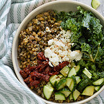 lentils in a bowl with sun dried tomatoes, kale, feta and cucumbers