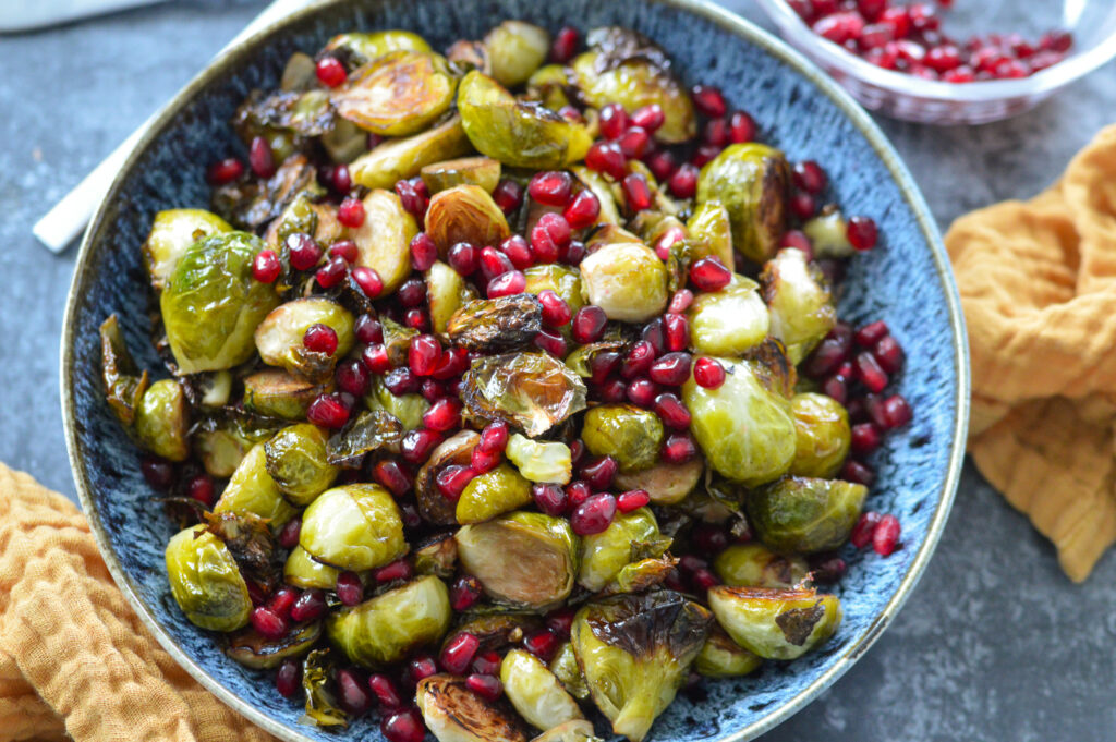 roasted brussels sprouts in a bowl with pomegranate seeds