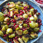 roasted brussels sprouts in a bowl with pomegranate seeds
